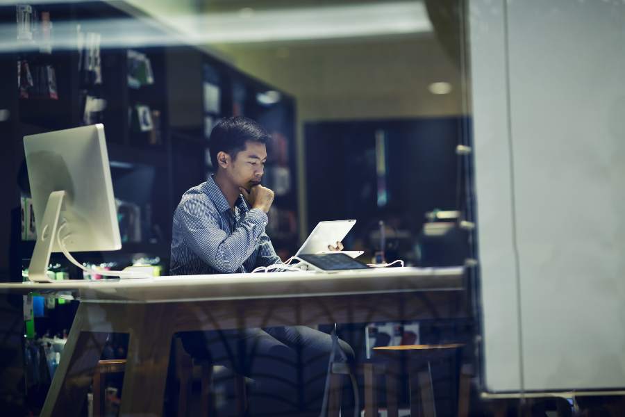 Asian businessman using tablet and PC in a meeting room.