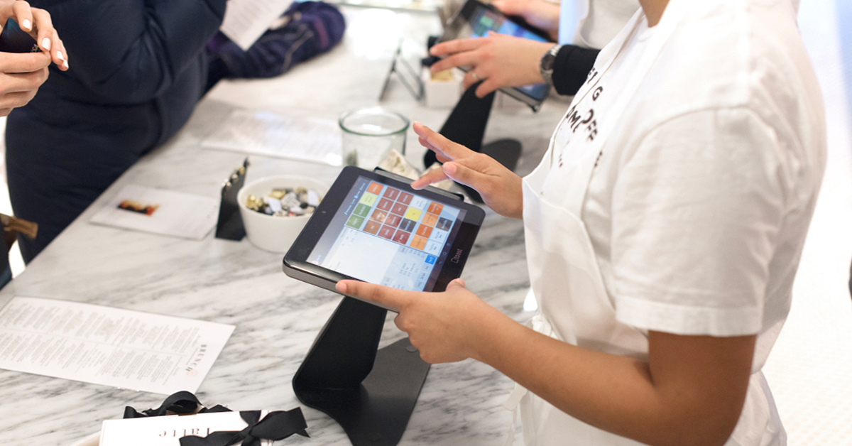 a cashier ringing in a sale on a Toast POS touchscreen